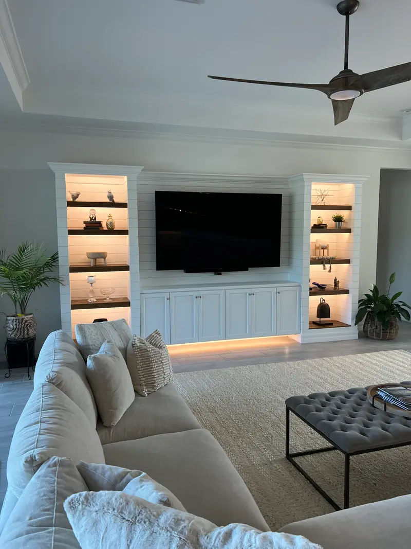 White shiplap built-ins with backlit shelving and cabinetry