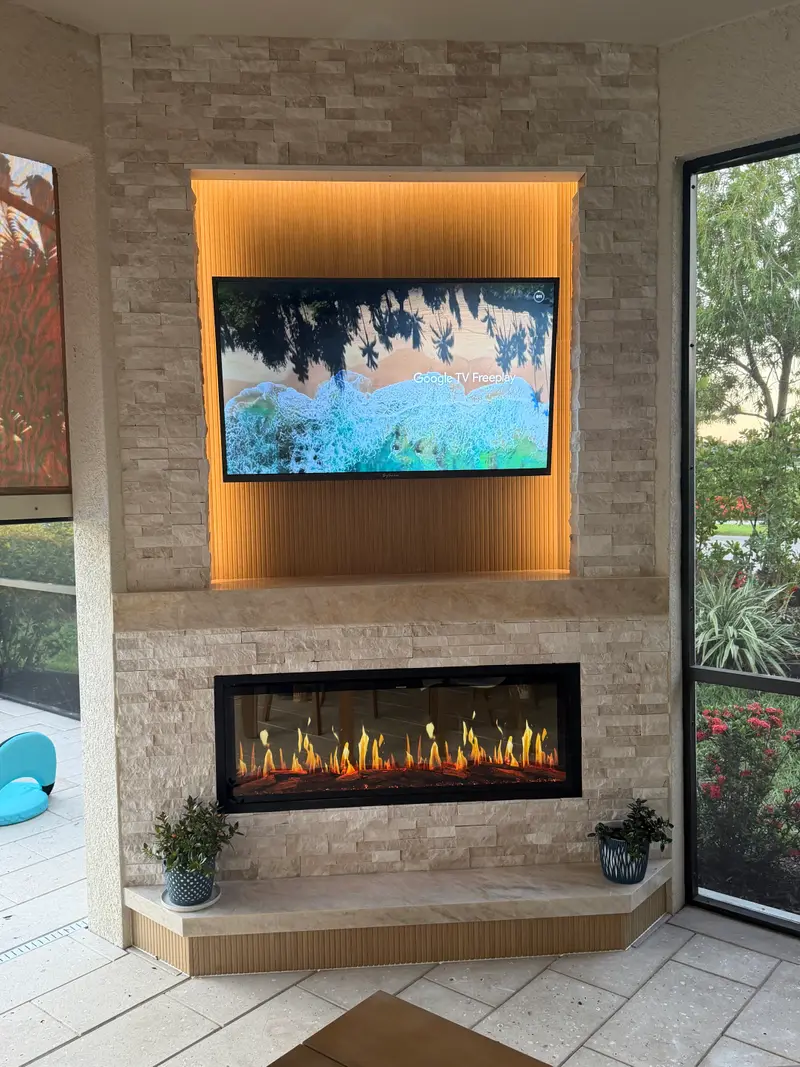 Stacked-stone outdoor electric fireplace on a screened lanai