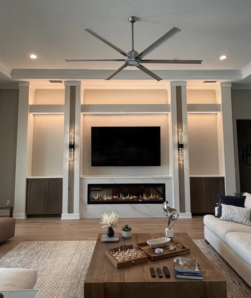 White built-in wall with lit columns, open shelving, a wall-mounted TV and a linear electric fireplace