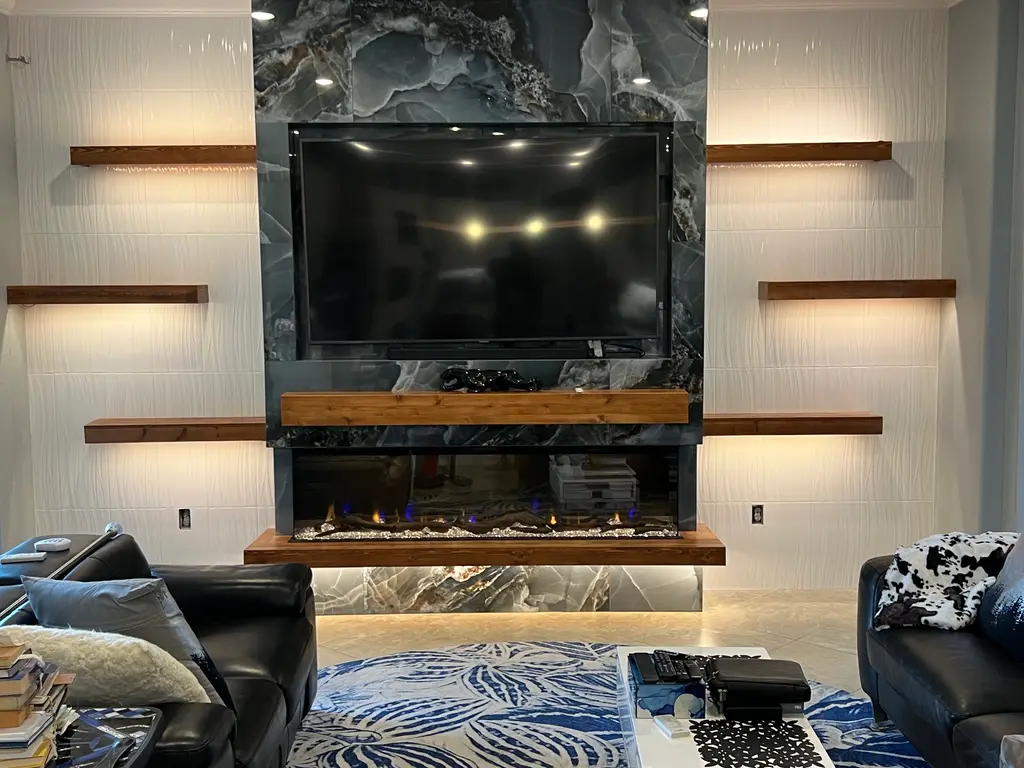 Blue onyx feature wall with live-edge wood mantel, floating shelves and a wide electric fireplace