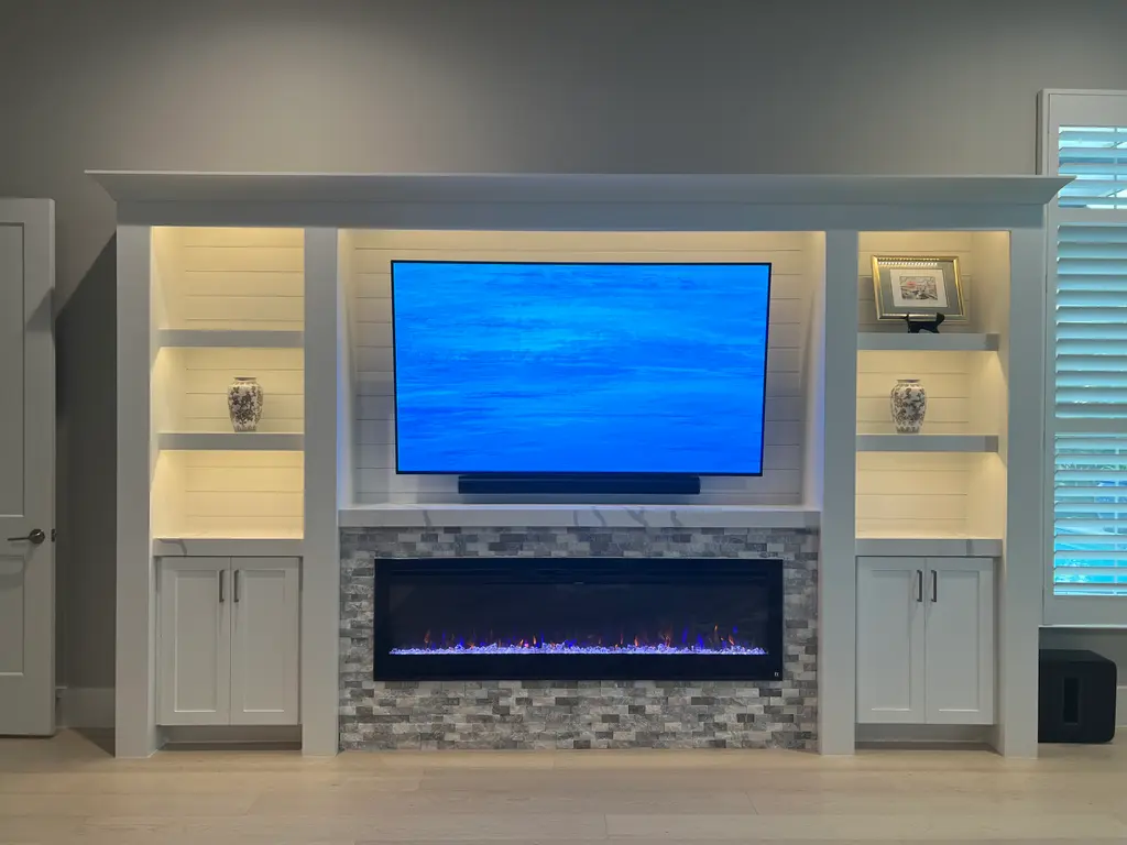 White built-in with shiplap, lit display shelves and a tile-surround linear fireplace