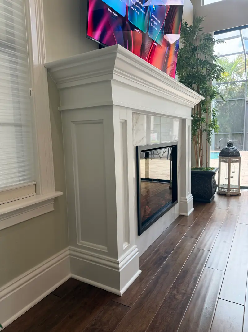 Traditional white mantel with a marble surround and an electric fireplace