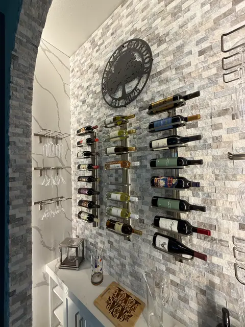 Close view of wine racks and glass holders on a stone mosaic wall
