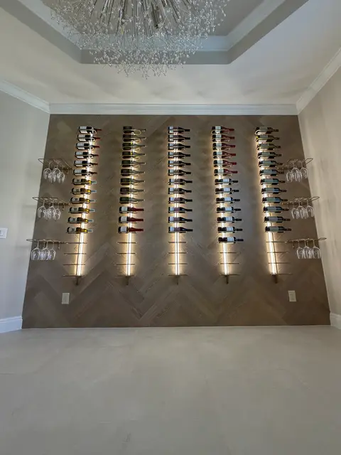 Full view of a herringbone wine wall with five lit rack columns