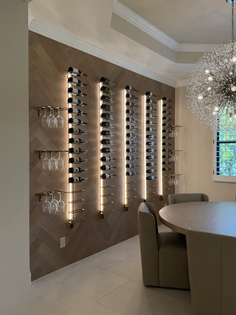 Close view of backlit floating bottles and stemware on a herringbone wood wall